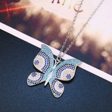 Detailed close-up of a butterfly pendant necklace featuring blue and white zircon stones