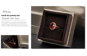 Lid and base jewelry box with velvet interior holding a ruby ring and heart necklace