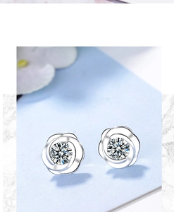 Detail view of silver flower stud earrings featuring a sparkling round cubic zirconia stone