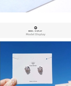 Detailed view of silver camellia earrings with sparkling cubic zirconia on jewelry card