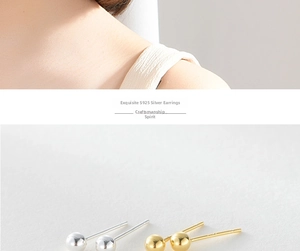 Macro detail of minimalist S925 sterling silver ball stud earrings in gold and silver