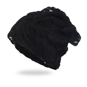 Detailed view of black crochet lace beanie with intricate floral openwork patterns