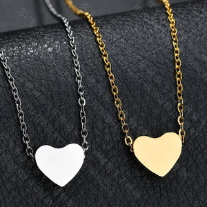 Primer plano de collares con colgante de corazón en oro y plata sobre cuero negro
