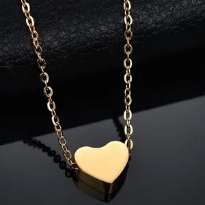 Vista macro de un collar con colgante de corazón 3D en acero inoxidable dorado pulido
