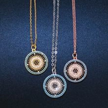 Detailed view of three circular pendants in gold, silver, and rose gold with blue stones