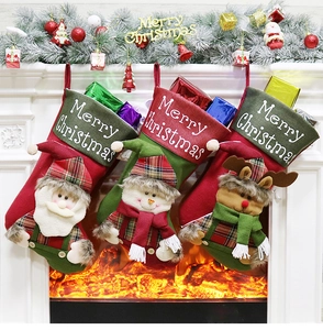 Three premium Christmas stockings featuring Santa, Snowman, and Reindeer hung on fireplace