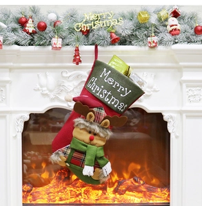 Detail of Christmas stocking with plush reindeer and Merry Christmas embroidery on fireplace