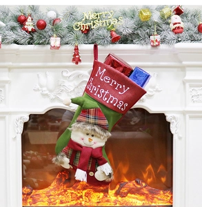 Detailed view of a snowman Christmas stocking hanging on a fireplace with warm light