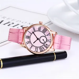 Detail view of pink crocodile leather strap and rose gold watch dial with Roman numerals