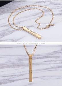 Detailed view of golden twisted steel bar pendant on O-chain against marble surface