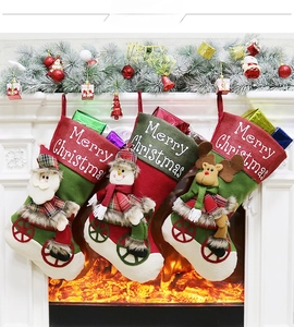 Detailed view of three 3D Christmas stockings featuring Santa, Snowman, and Reindeer hanging