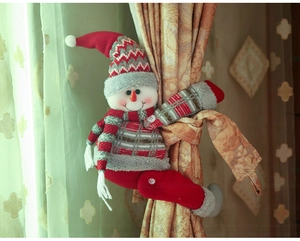 Close-up of a festive snowman curtain buckle with red knitted hat on champagne drapes
