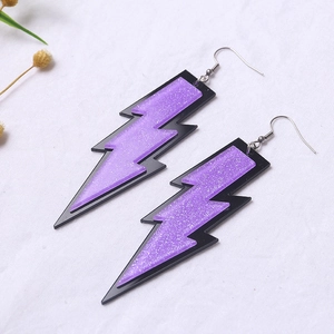 Detailed view of purple glitter lightning bolt acrylic earrings with black borders