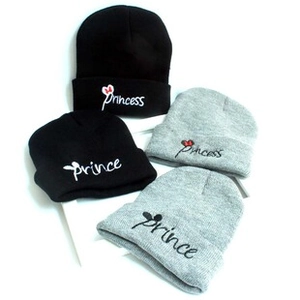 Detailed view of knitted beanies featuring Prince and Princess embroidery and ear motifs