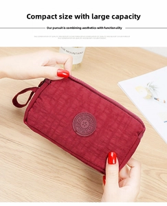 Vista ravvicinata dell'organizer in nylon rosso vino con tre cerniere e stemma sportivo