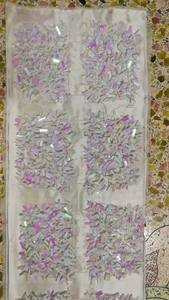 Detailed view of six fabric patches featuring intricate holographic beadwork and sequins