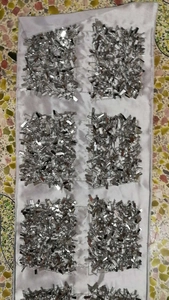 Close-up of silver sequins and beadwork embroidery on light grey evening bag fabric