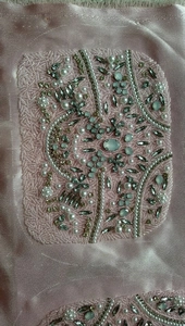 Detailed view of handmade pink silk clutch with intricate pearl and sequin embroidery