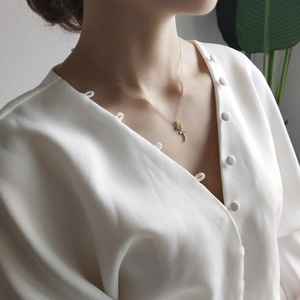 Close-up of a 925 sterling silver rose flower pendant necklace worn by a female model