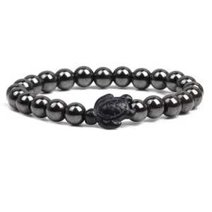 Handmade hematite beaded bracelet featuring a matte black turtle charm on white background