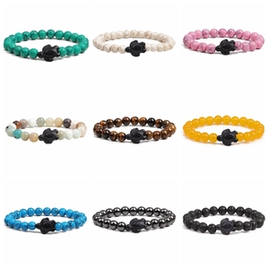 Close-up of nine beaded bracelets with various stone textures and black turtle charms
