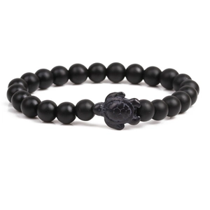 Detailed view of matte black beaded bracelet featuring a unique sea turtle centerpiece