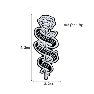 Gothic rose enamel pin with black ribbon and Living in Perpetual Sin text detail
