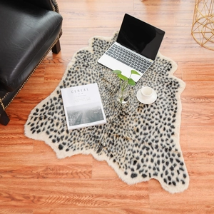 Detailopname van een luipaardprint imitatiebont tapijt op houten vloer met decoratie