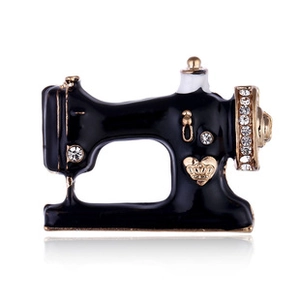 Macro shot of vintage sewing machine brooch with black enamel and sparkling crystals