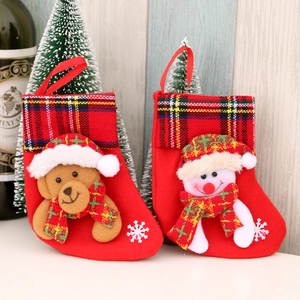 Pair of red Christmas stockings with plush bear and snowman on a holiday background