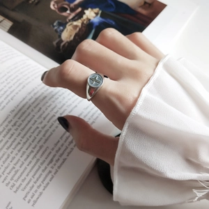 Macro shot of silver cross ring with vintage relief design on an open book background