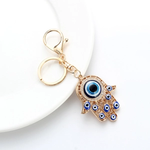 Macro shot of Hamsa hand keychain with blue evil eye charms and rhinestone accents