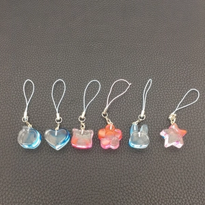 Close-up of six-piece set iridescent animal and heart pendants on black leather