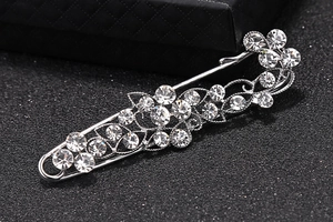 Macro shot of silver alloy brooch featuring intricate floral crystal rhinestone patterns