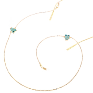 Golden metal eyewear chain with owl pendants and blue beads on a white background