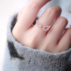 Rose gold adjustable angel wing ring with pavé sparkling crystals on a finger