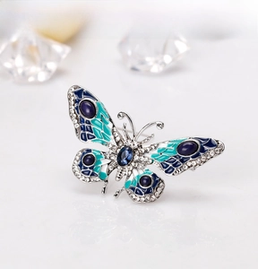 Macro shot of butterfly brooch with blue enamel wings and sparkling inlaid rhinestones
