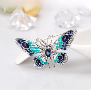 Macro detail of butterfly brooch with blue enamel wings and sparkling crystal rhinestones