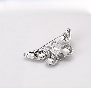 Detailed back view of a silver butterfly brooch showing secure pin clasp and textured wings