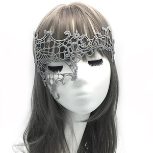 Detail of silver lace phoenix mask for masquerade party showing intricate fabric texture