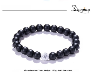 Detail of 8mm matte black stone beads and a single white marble turquoise bead bracelet