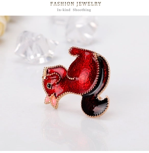 Detailed close-up of a red enamel squirrel brooch with golden edges on white base