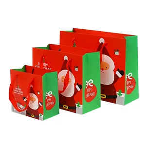 Three Christmas gift bags in red and green with Santa and reindeer designs