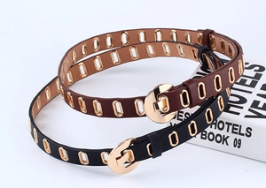 Detail of PU leather belts with gold metal eyelets and round pin buckles in black and brown