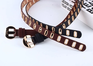 Detail of black and brown PU leather belts with golden oval eyelets and round pin buckles