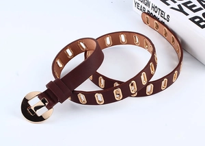 Detail of dark brown PU leather belt with gold metal eyelets and U-shaped pin buckle