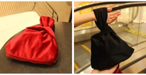 Close-up of red and black velvet wristlet bags with knotted handles for elegant parties