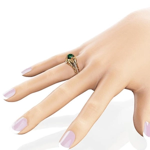 Primo piano di anello vintage in oro con smeraldo verde e lavorazione metallica traforata