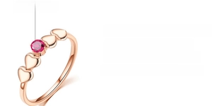 Close-up of 18k rose gold heart ring with red corundum in a hex-prong setting