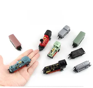 Detailansicht eines Miniatur-Vintage-Eisenbahnsets mit bunten Dampflokomotiven und Waggons